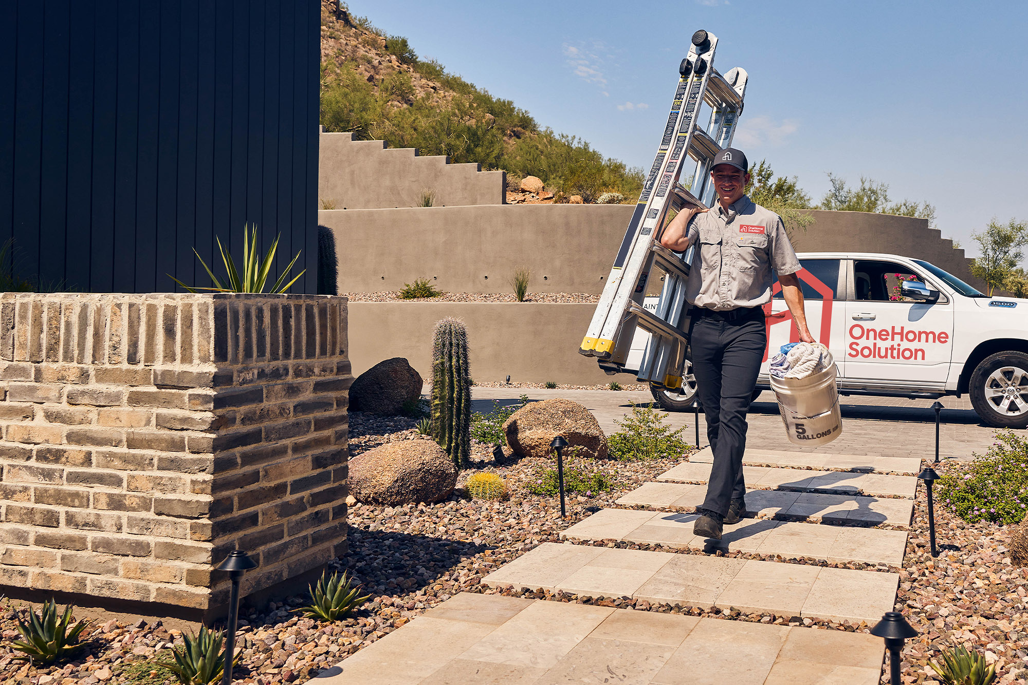 A OneHome Solution technician arriving at an Arizona home with a ladder and supplies