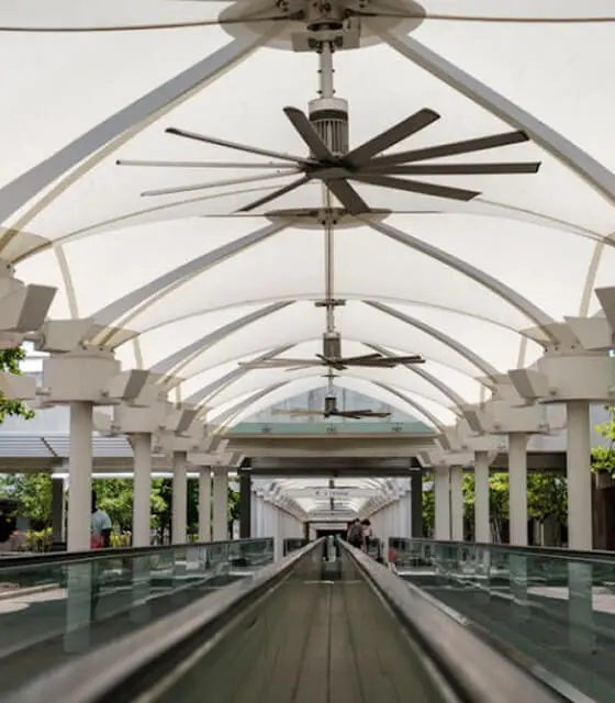 Technician installing a modern ceiling fan in a living room