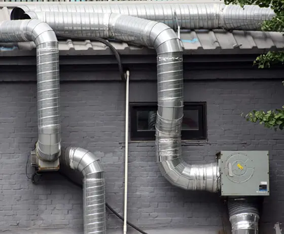 Technician using specialized tools to clean a residential dryer vent system