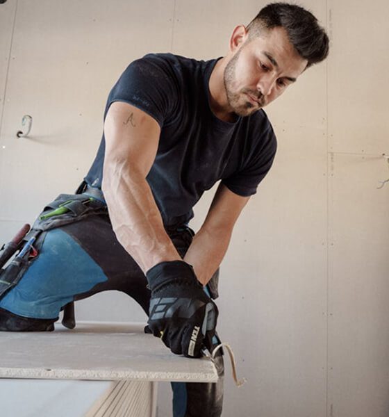 Handyman installing drywall panels in a residential home