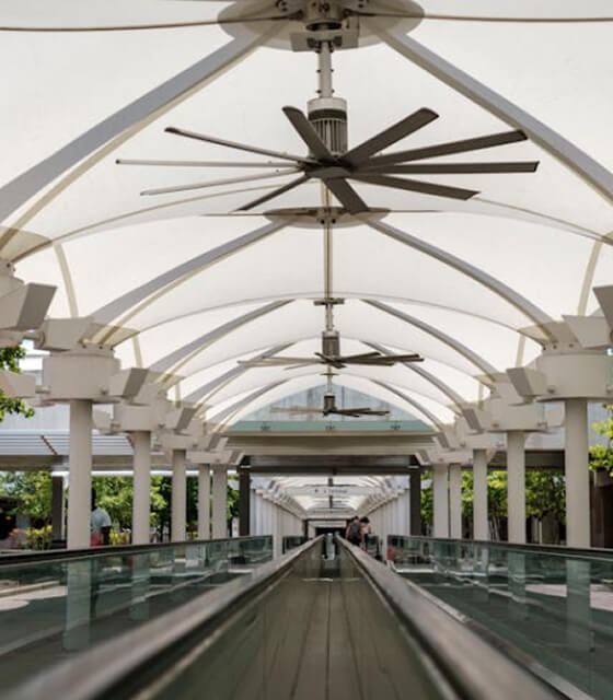 Technician installing a modern ceiling fan in a living room